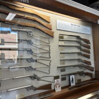 Early years display case showing vintage Daisy BB guns and rifles at Daisy Airgun Museum