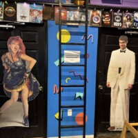 Retro bathroom doors with geometric patterns and life-size cutouts at Flashback Pizza & Milkshakes in Rogers, Arkansas