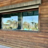 Exterior view of the Tanked aquarium at Salt Life Food Shack framed like a window in the wood plank wall in St. Augustine Beach Florida