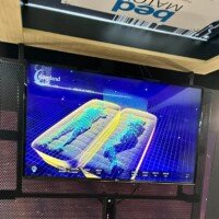 BedMatch screen displaying a 3D heat-mapped pressure visualization of two mattresses side by side, shown beneath the illuminated BedMatch sign