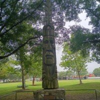 Peter Toth's Whispering Giant sculpture standing beneath trees at Mount Trashmore Park in Virginia Beach, Virginia.