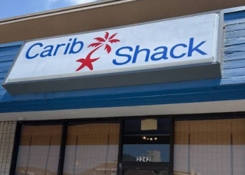 Carib Shack storefront in the Seashore Shoppes, with its blue-and-white sign above the entrance.