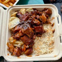 Close-up of Carib Shack’s Jerk Pork Bowl with glossy jerk barbecue pork, cabbage, carrots, and white rice.