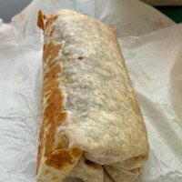 Mason’s large Shack Burrito folded closed and resting on its paper wrapper.