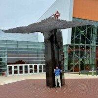 Nancy reacting as if she hears something beneath the giant falcon statue at BGSU