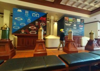 Educational display comparing the Bud Light and Budweiser brewing processes, with decorative fermenter-shaped columns in the tasting room.