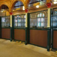 Ornate Clydesdale stable interior at Anheuser-Busch, with named stalls including King and General under stained glass windows.