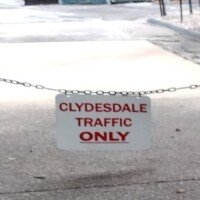 A sign reading Clydesdale Traffic Only hanging on a chain across a driveway at the Anheuser-Busch brewery.