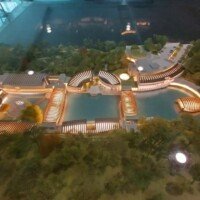 Illuminated architectural scale model of the Crystal Bridges Museum campus, showing the pavilions and ponds.