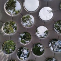 Looking straight up through the circular openings of Buckminster Fuller's Fly's Eye Dome to the sky and treetops at Crystal Bridges Museum.