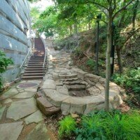 Stone spring feature and staircase built into the hillside next to the museum building at Crystal Bridges.