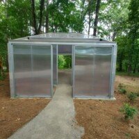 Translucent polycarbonate pavilion structure with a walkway leading through the woods at Crystal Bridges Museum.