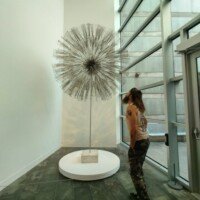 Zach looking up at a large starburst-shaped sculpture inside Crystal Bridges Museum.