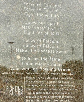 Forward Falcons plaque explaining BGSU's 1927 Falcons nickname history near the Bronze Falcon statue